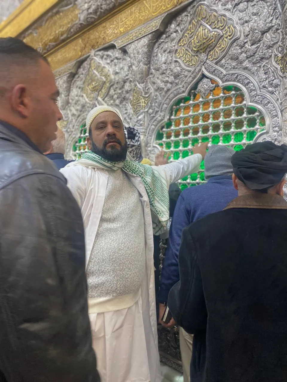 Group of men praying near shrine