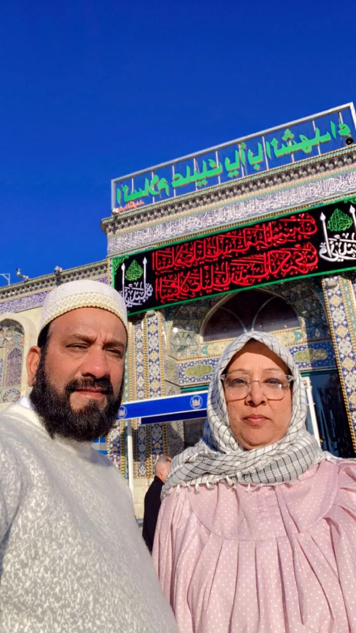Man and woman standing near shrine gate